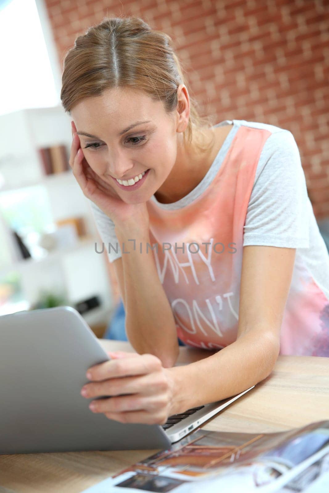 Portrait of young woman at home working on laptop