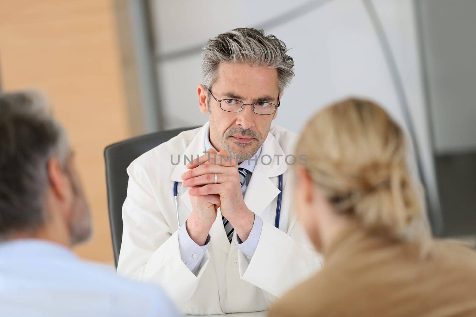Doctor meeting couple in hospital office