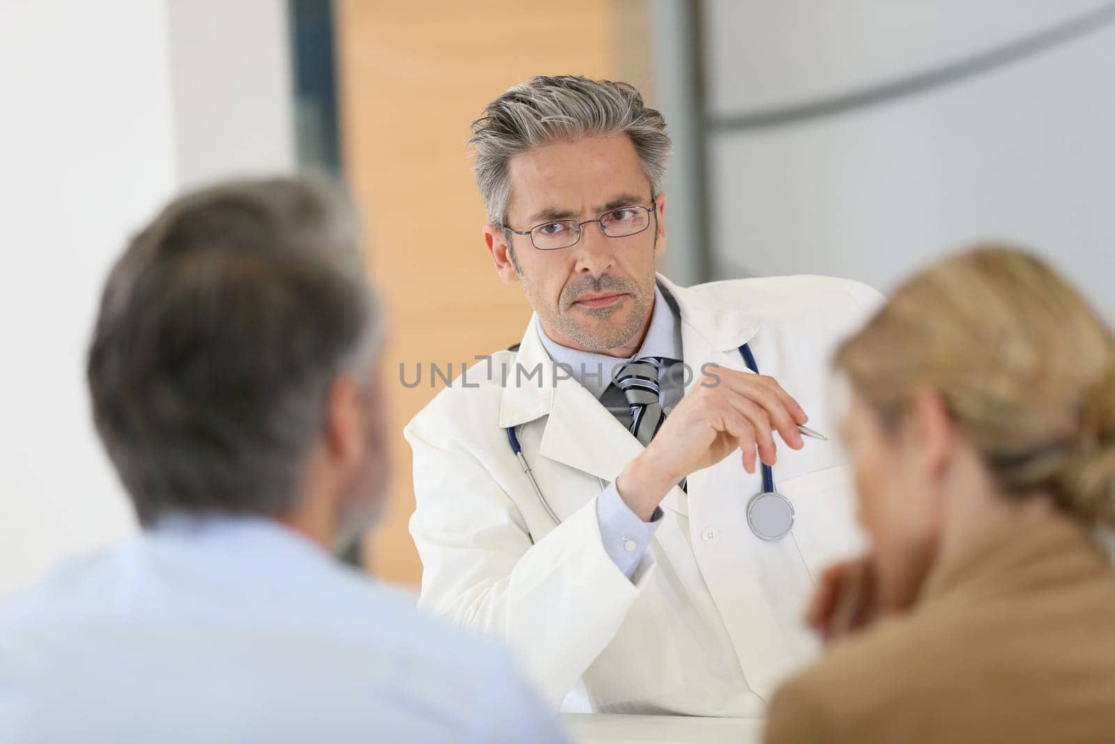 Doctor meeting couple in hospital office
