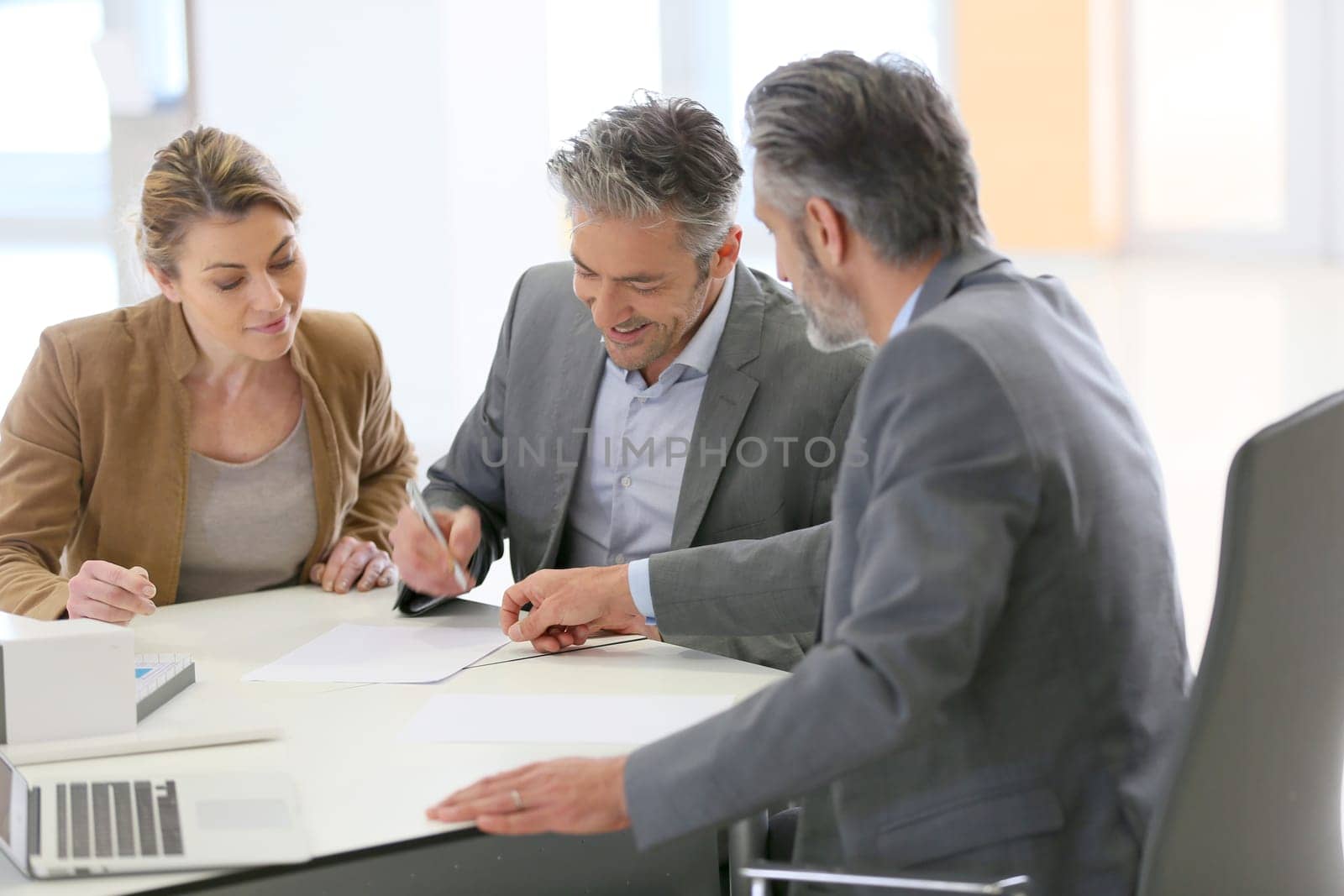 Mature couple signing construction contract in architect's office