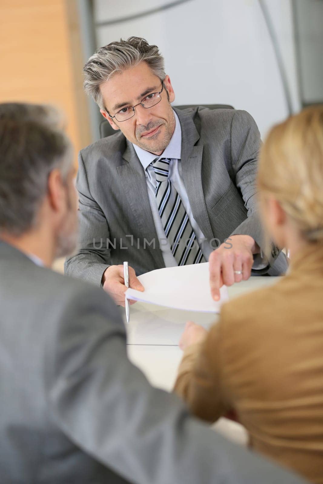 Mature couple signing contract in lawyer's office