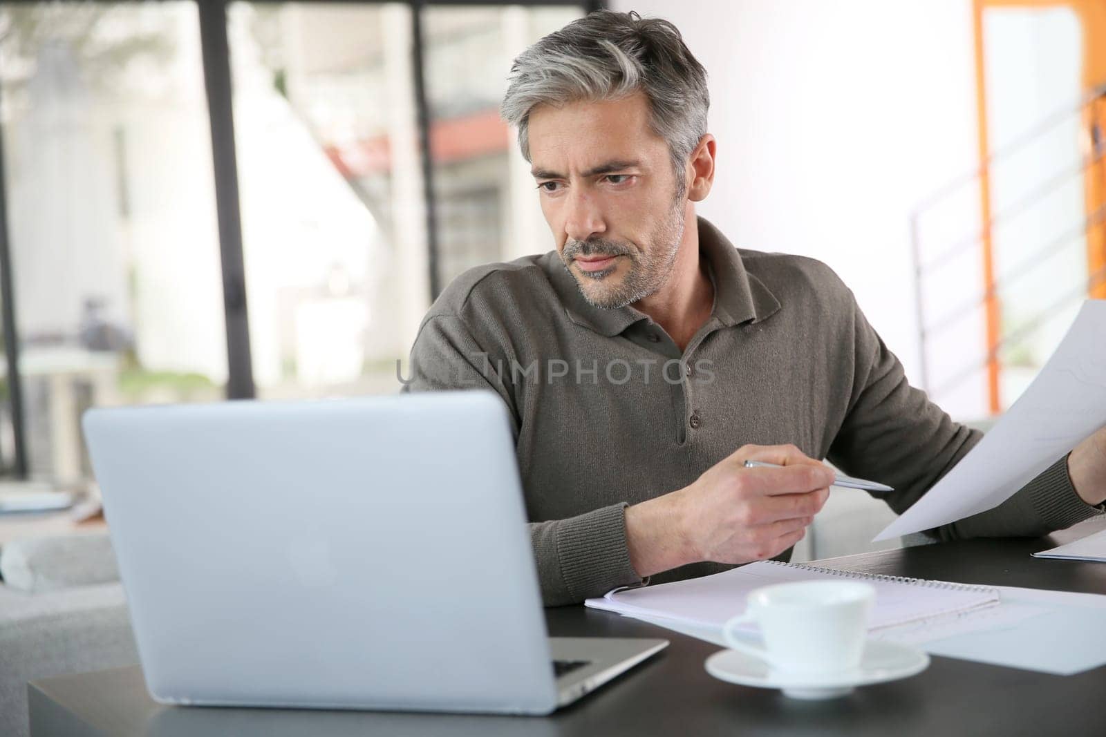 Mature man calculating budget on laptop