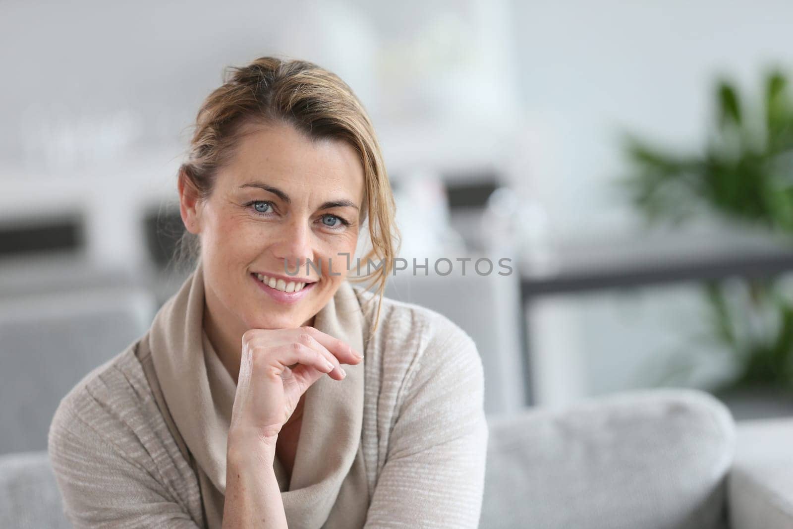 Portrait of smiling mature woman with hand on chin