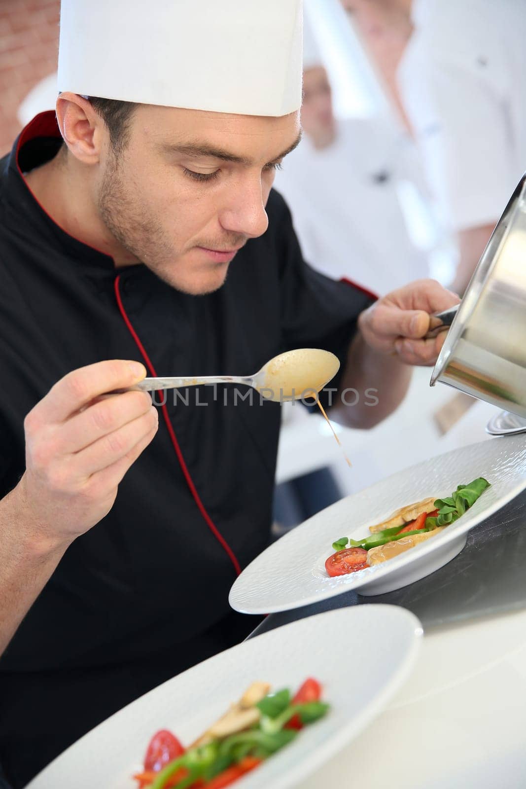 Chef in restaurant kitchen preparing dish