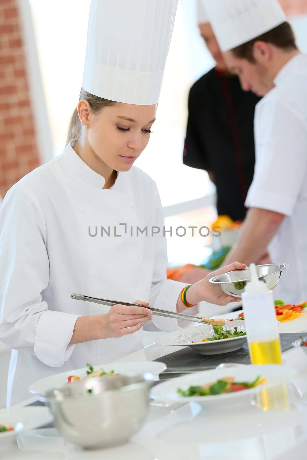 Girl in cooking training class preparing dish