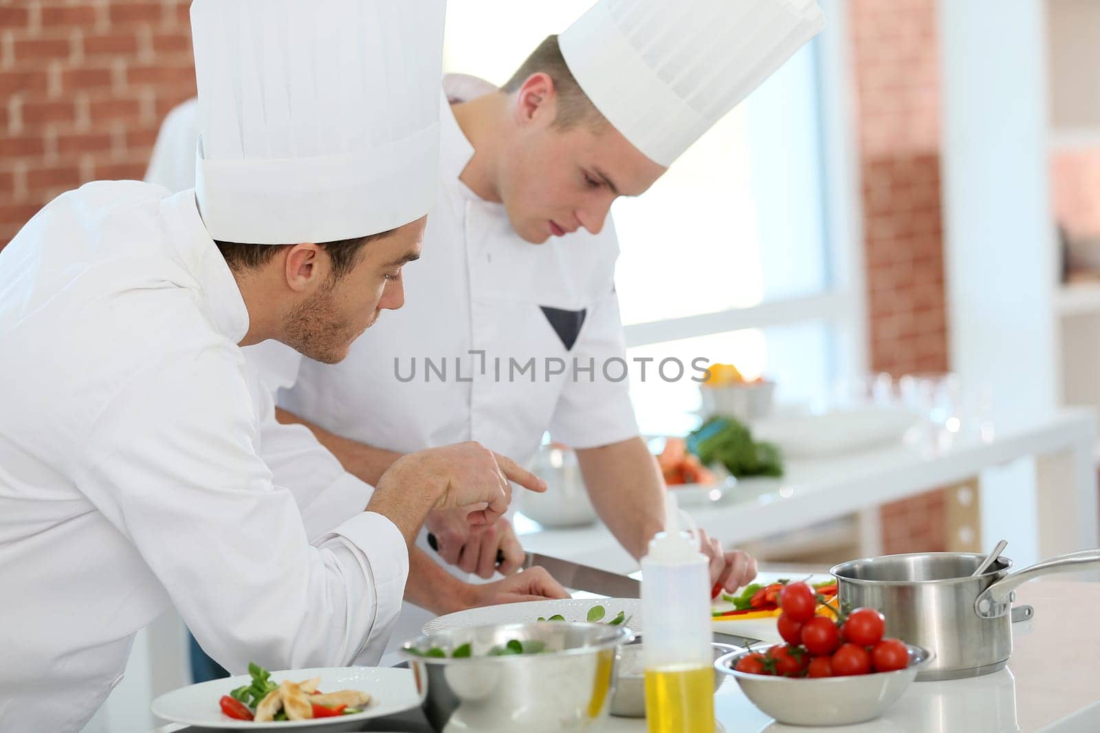Chef training students in restaurant kitchen