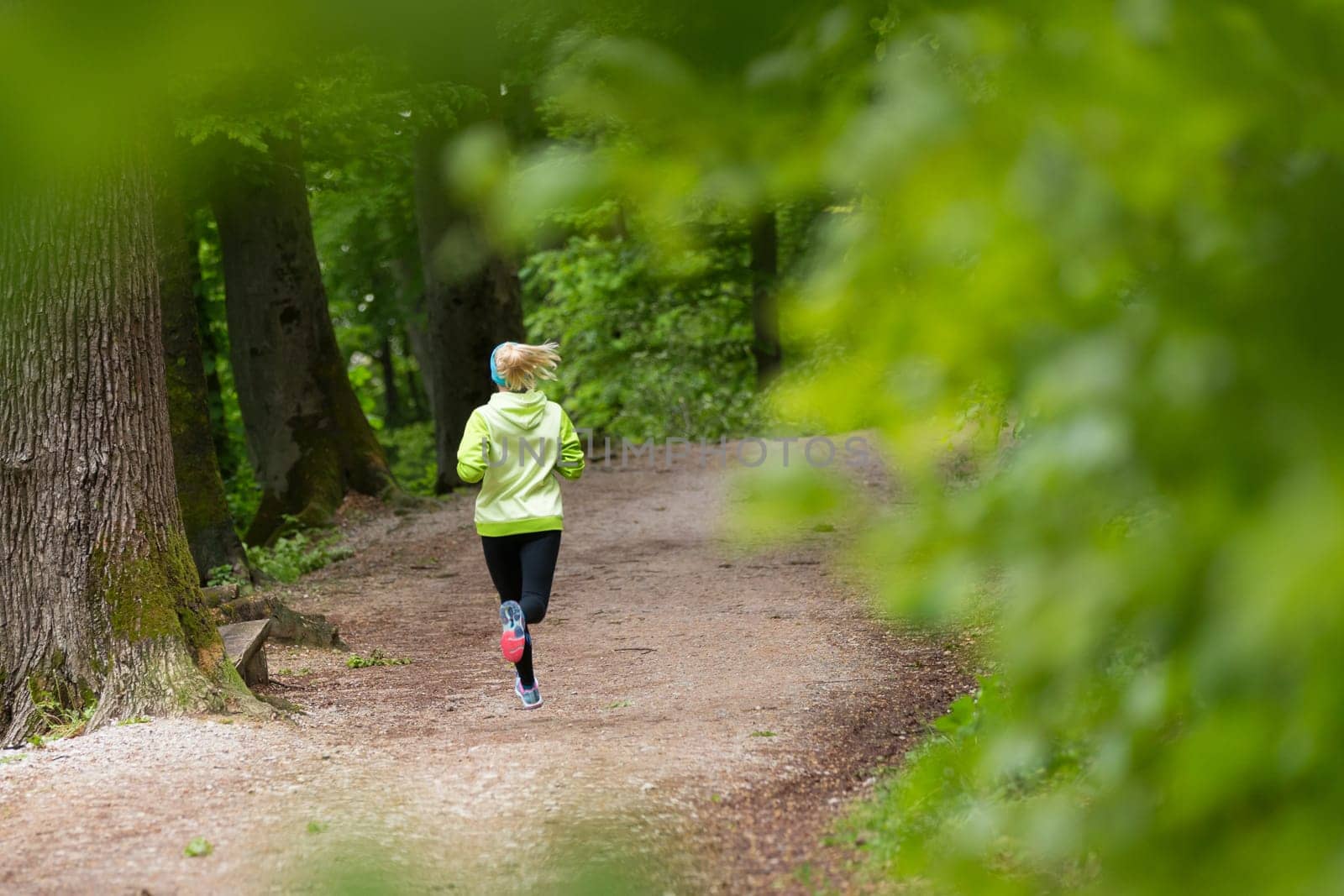 Sporty young female runner in forest.  Running woman. Female runner during outdoor workout in nature. Fitness model outdoors. Weight Loss. Healthy lifestyle.
