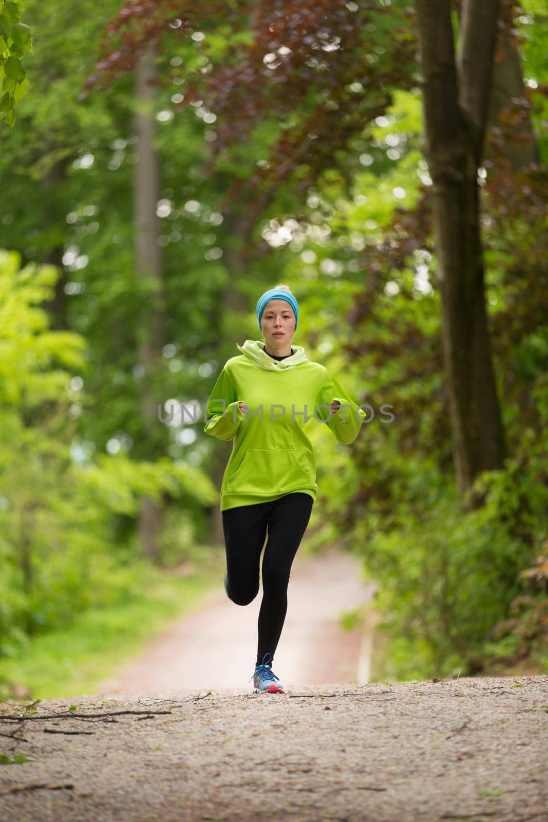 Sporty young female runner in forest.  Running woman. Female runner during outdoor workout in nature. Fitness model outdoors. Weight Loss. Healthy lifestyle.