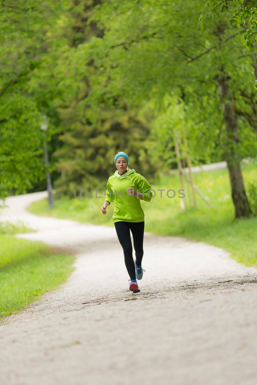 Sporty young female runner in city park.  Running woman. Female runner during outdoor workout in nature. Fitness model outdoors. Weight Loss. Healthy lifestyle.
