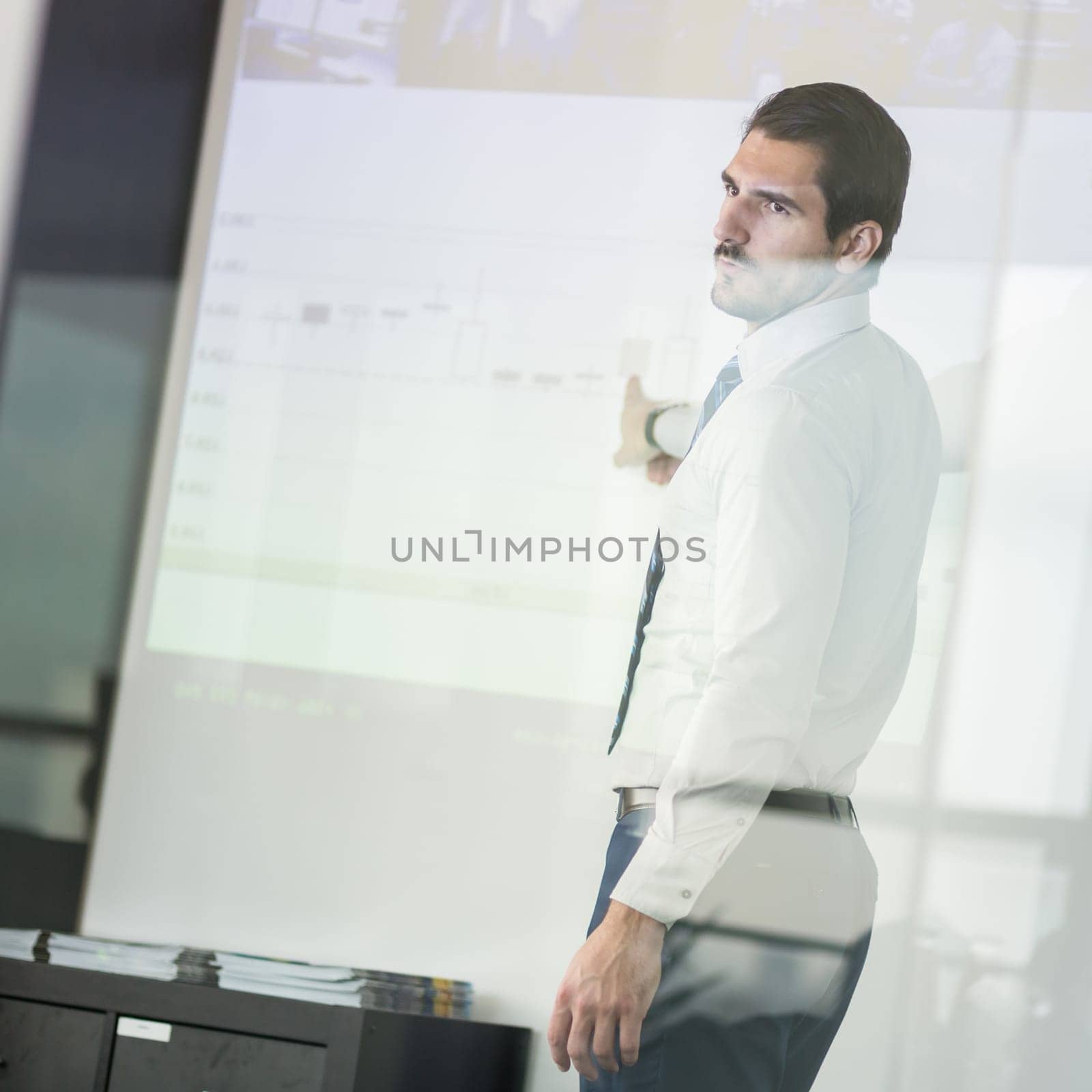 Businessman making a presentation in front of whiteboard. Business executive delivering a presentation to his colleagues during meeting or in-house business training.