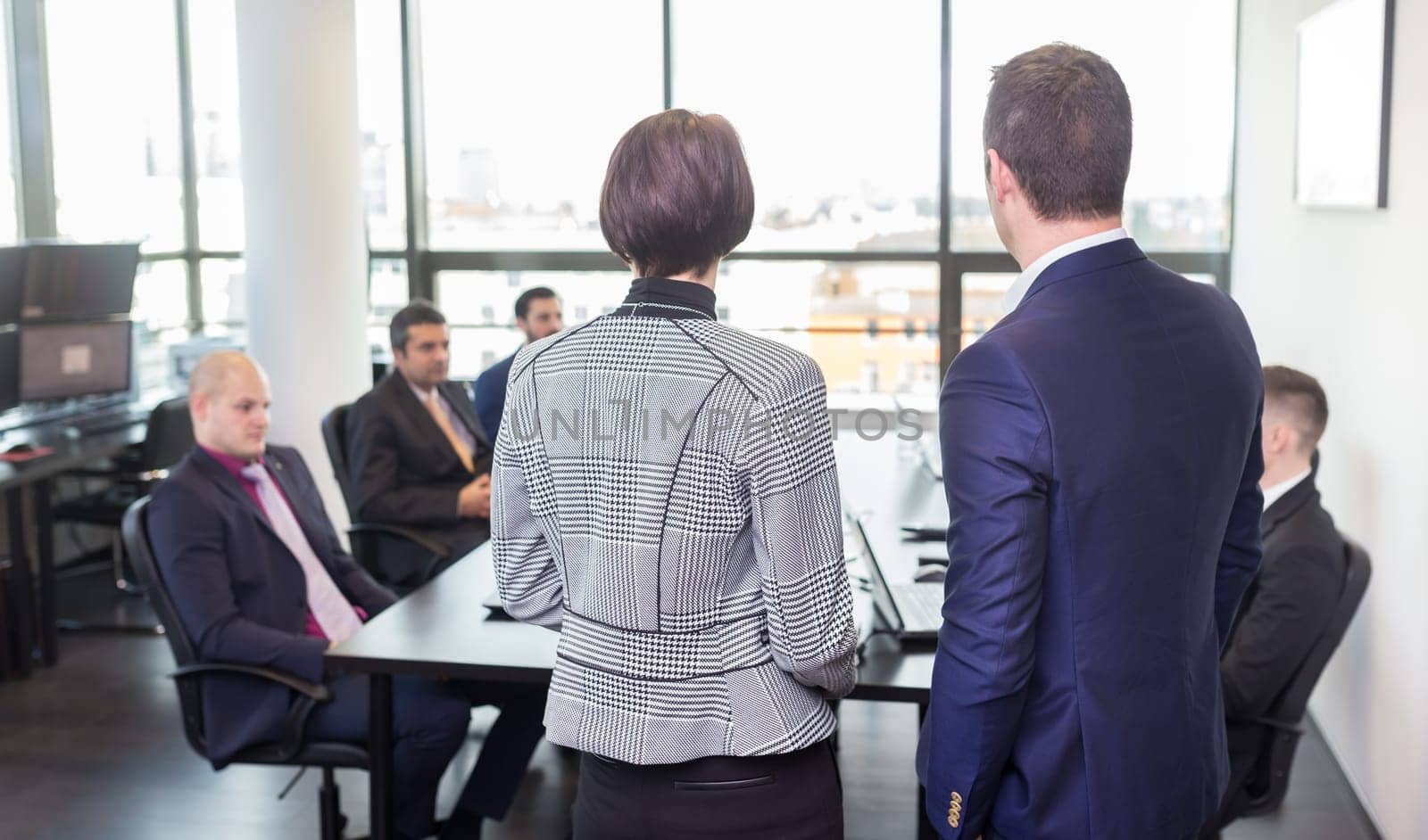 Successful team leader and business owner leading in-house business meeting, explaining business plans to his employees. Business and entrepreneurship concept.