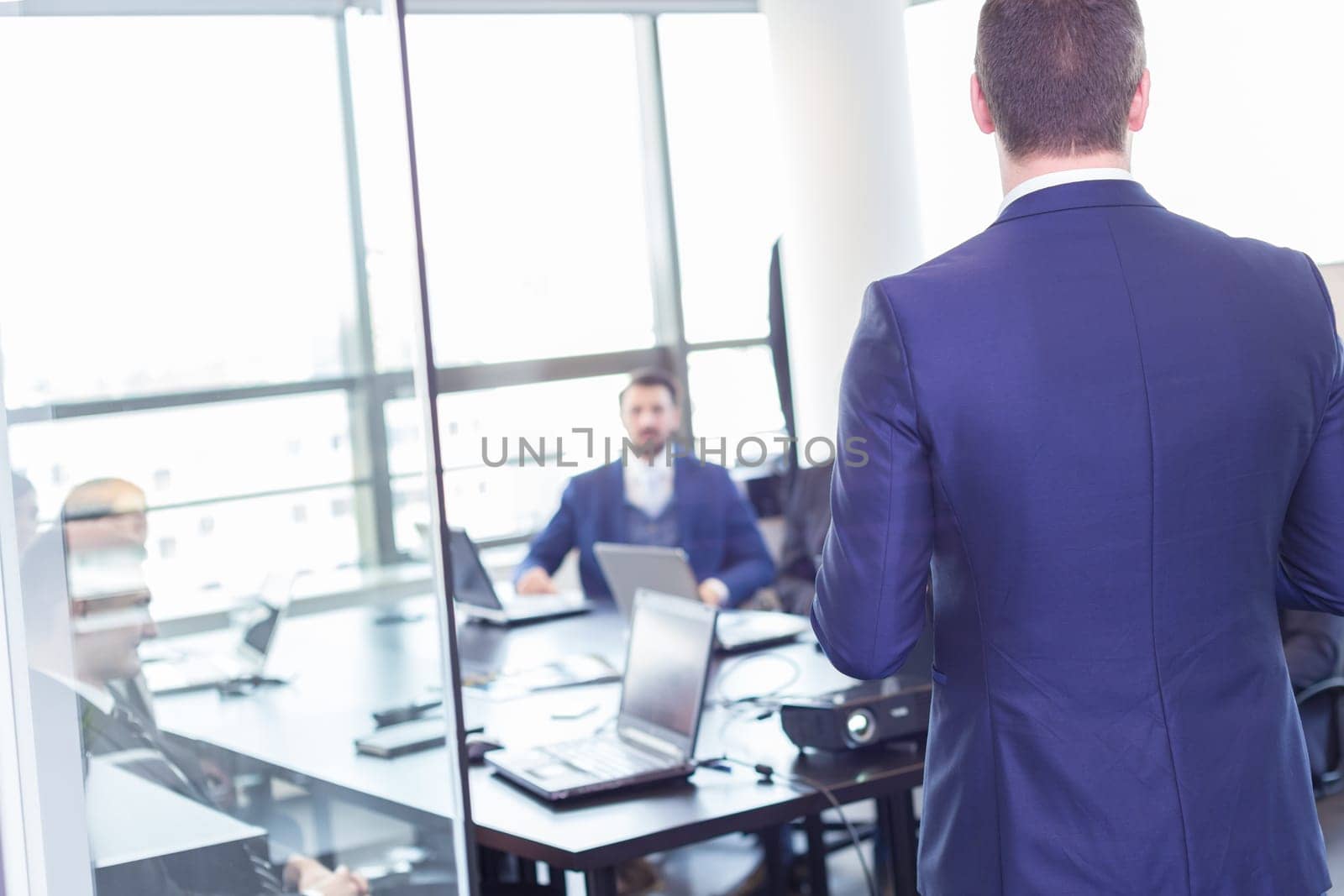 Business man making a presentation at office. Business executive delivering a presentation to his colleagues during meeting or in-house business training, explaining business plans to his employees.