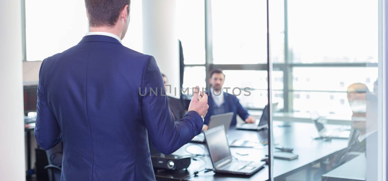 Business man making a presentation at office. Business executive delivering a presentation to his colleagues during meeting or in-house business training, explaining business plans to his employees.