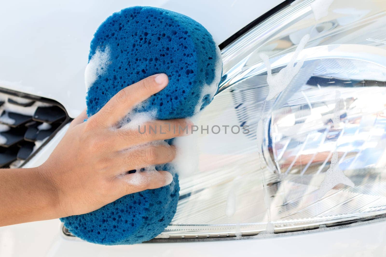 close up hand using sponge washing car