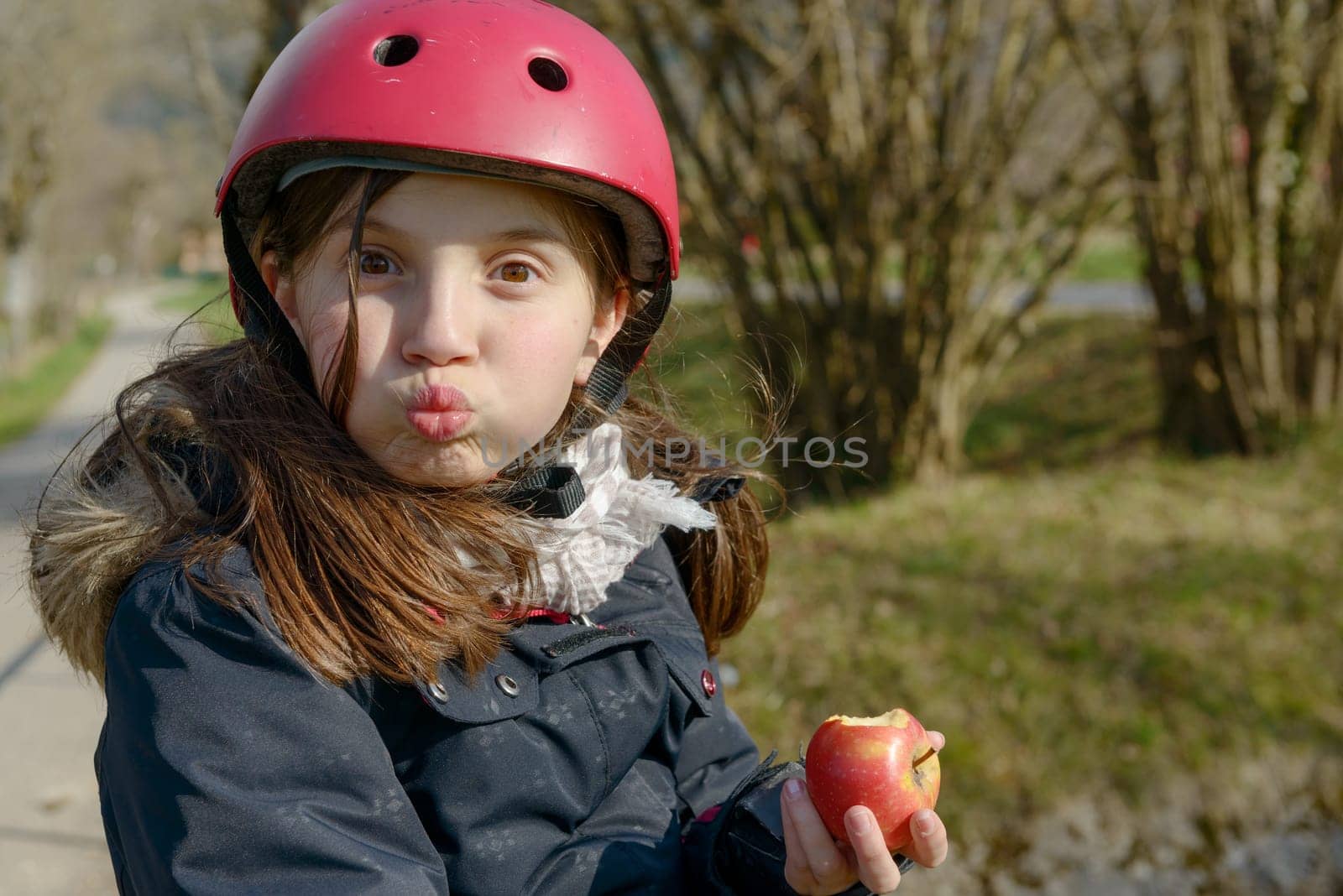 pretty preteen with roller skate helmet, eat an apple