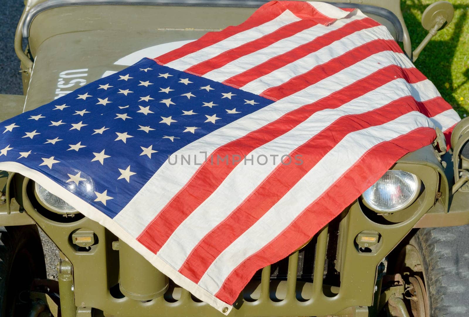 a ww2 military vehicle, jeep,with American flag