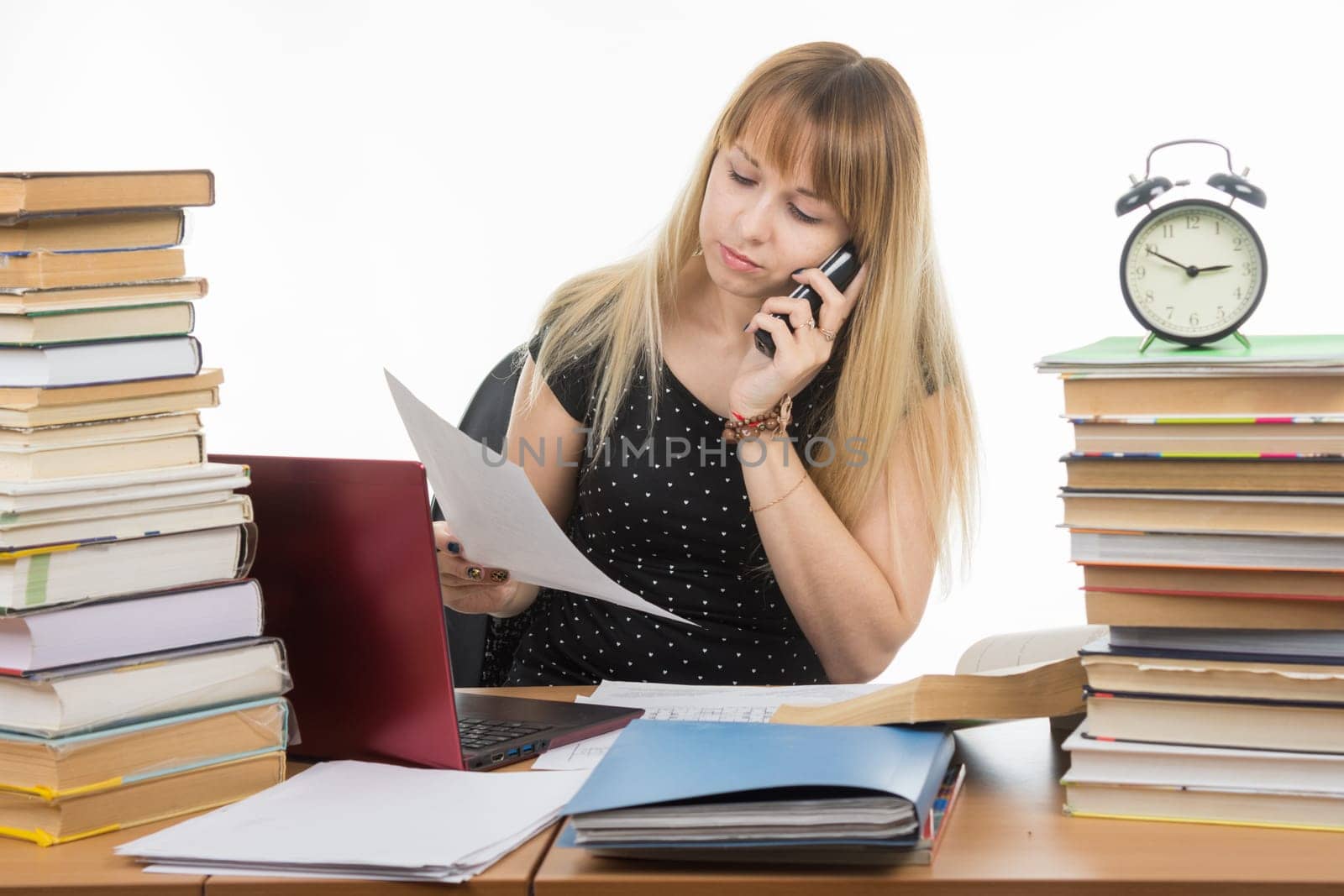 Teacher discusses by phone written on a sheet of paper