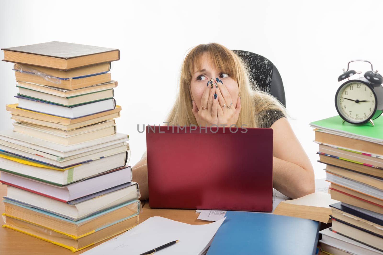 Student shocked smorit a large stack of textbooks