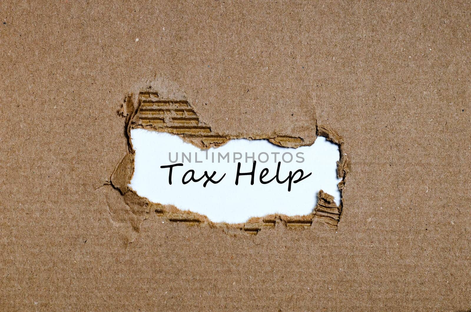 The word tax help appearing behind torn paper.
