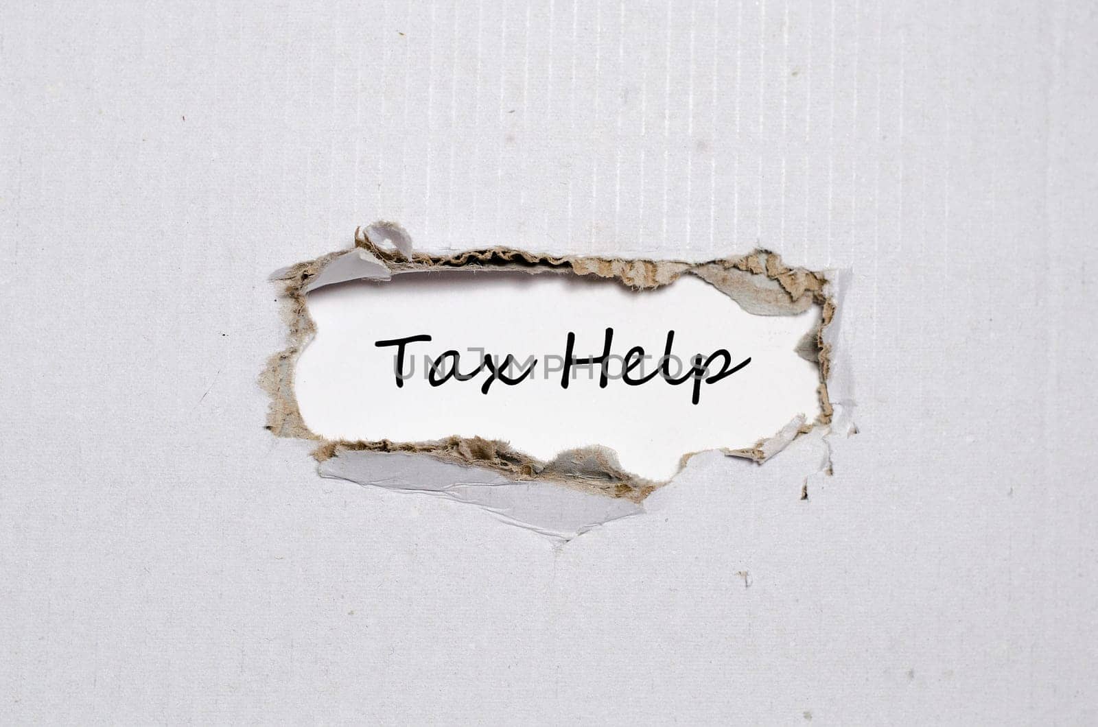 The word tax help appearing behind torn paper.