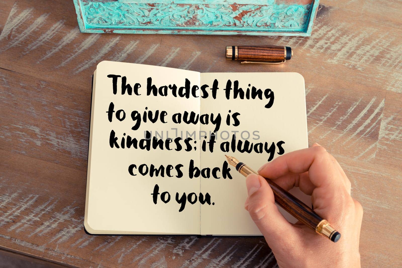 Retro effect and toned image of a woman hand writing on a notebook. Handwritten quote See with your mind, hear with your heart as inspirational concept image