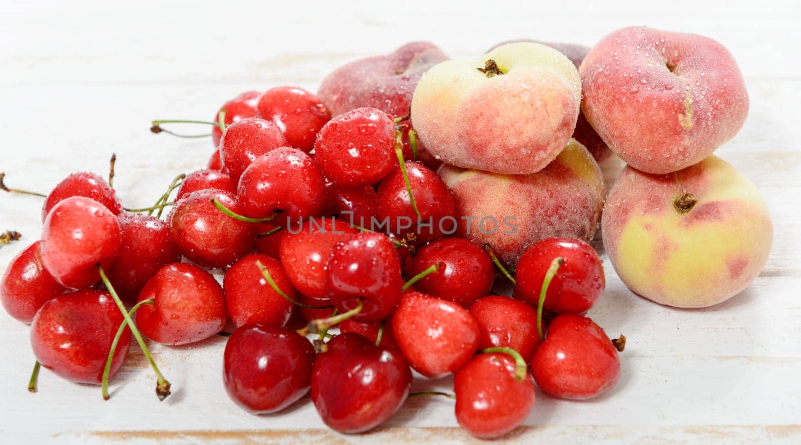 cherries and peaches on the white wooden table