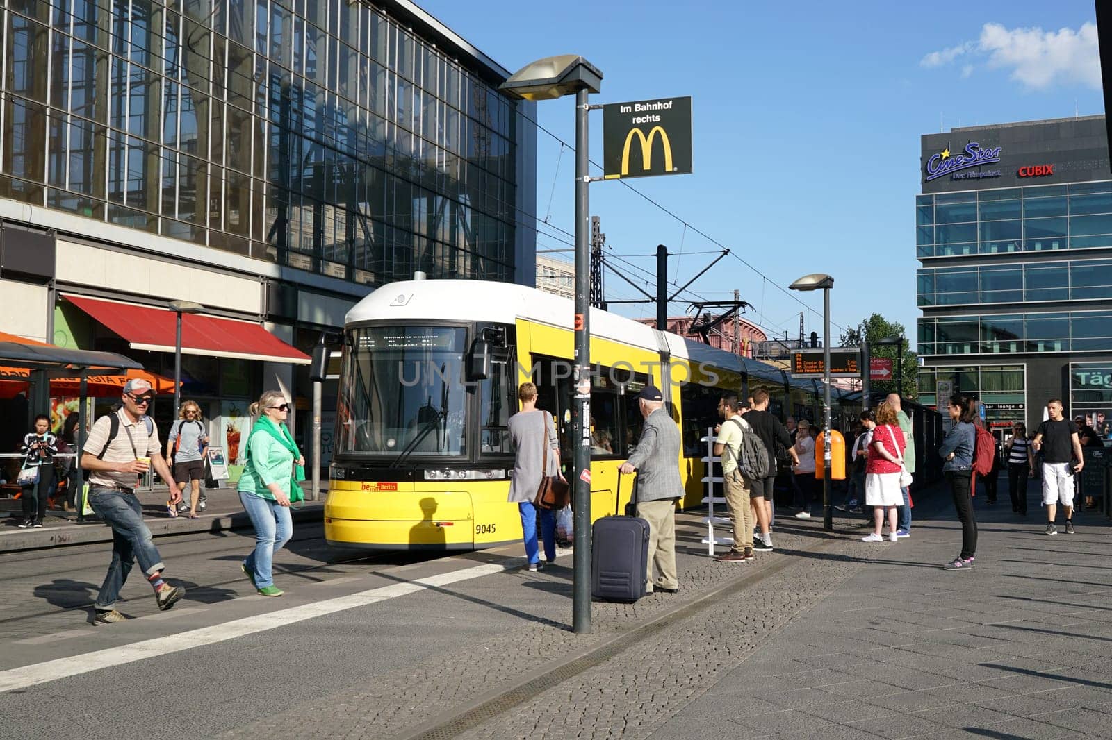 Tourists and residents at a tram stop at Alexanderplatz in the center of Berlin