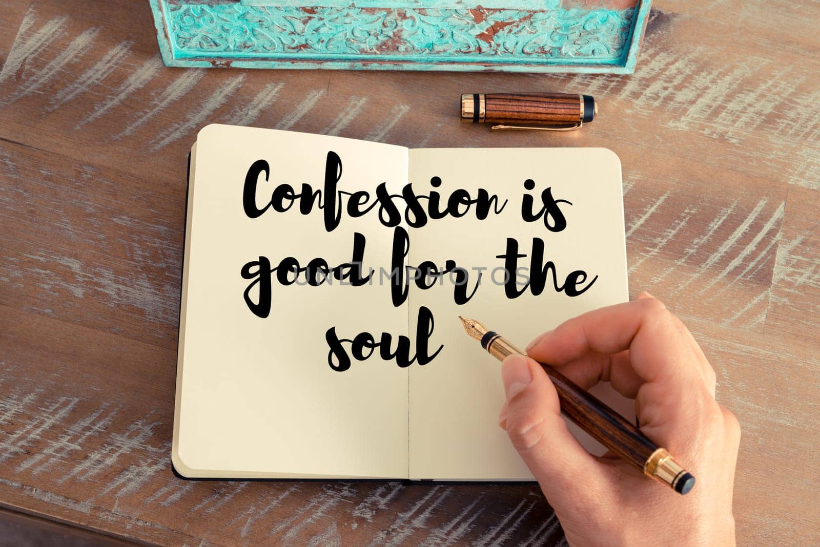 Retro effect and toned image of a woman hand writing on a notebook. Handwritten quote Confession is good for the soul as inspirational concept image