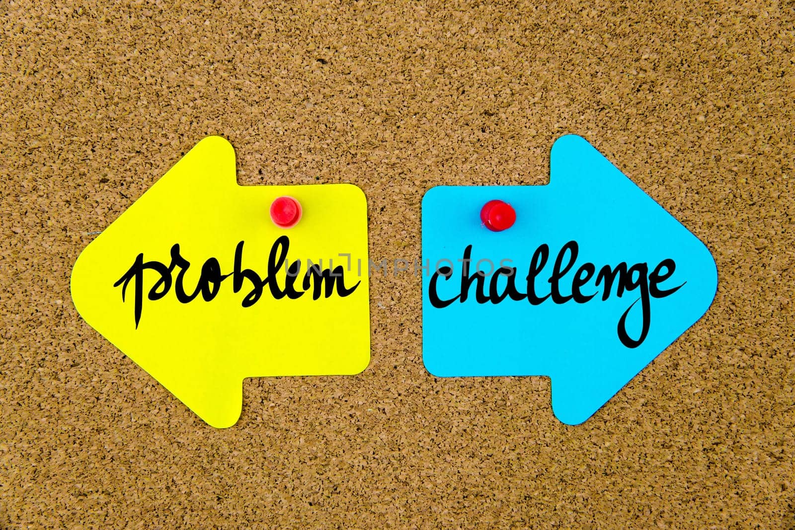 Blank yellow and blue paper notes in shape of opposite arrows pinned on cork board with thumbtacks, copy space available