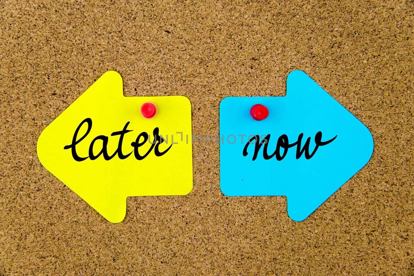 Blank yellow and blue paper notes in shape of opposite arrows pinned on cork board with thumbtacks, copy space available