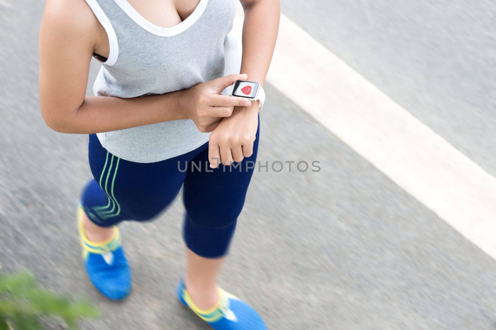 sport woman use digital hand watch checking health application on road