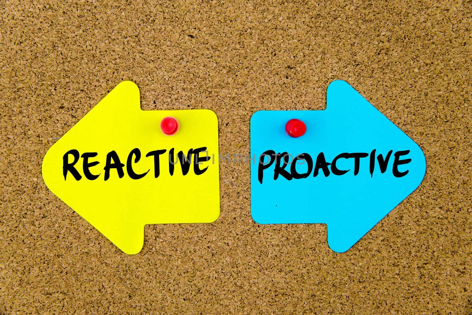 Blank yellow and blue paper notes in shape of opposite arrows pinned on cork board with thumbtacks, copy space available