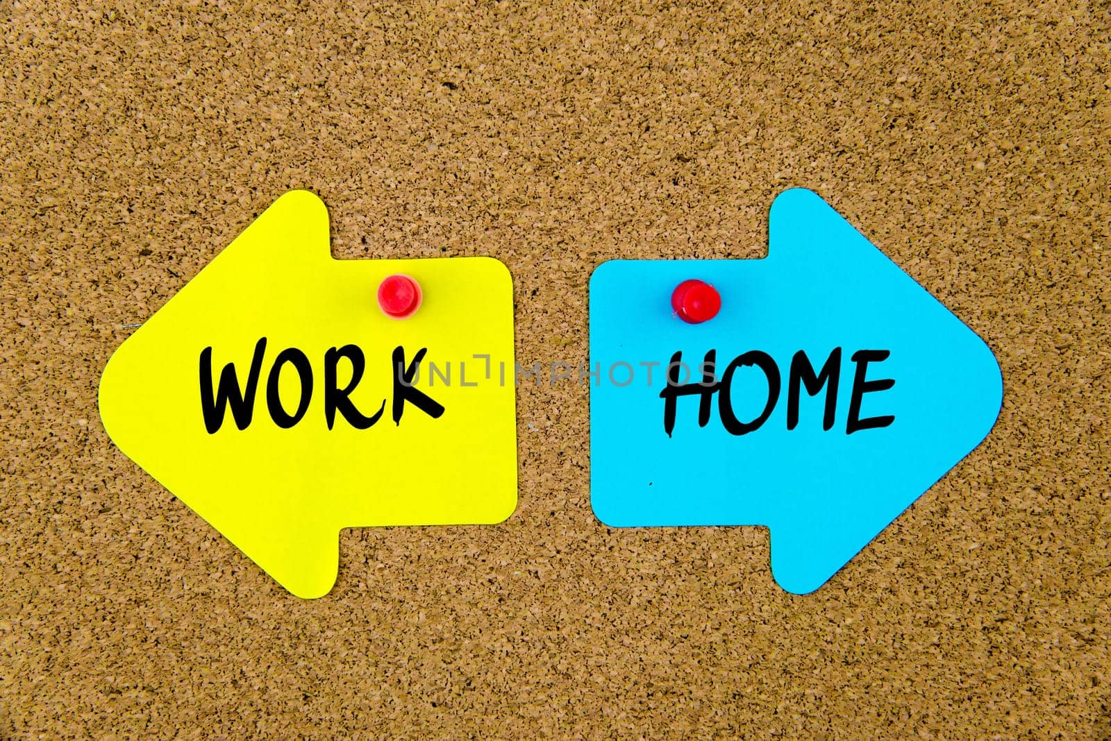 Blank yellow and blue paper notes in shape of opposite arrows pinned on cork board with thumbtacks, copy space available