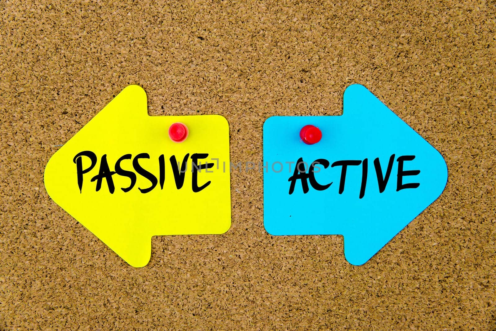 Blank yellow and blue paper notes in shape of opposite arrows pinned on cork board with thumbtacks, copy space available