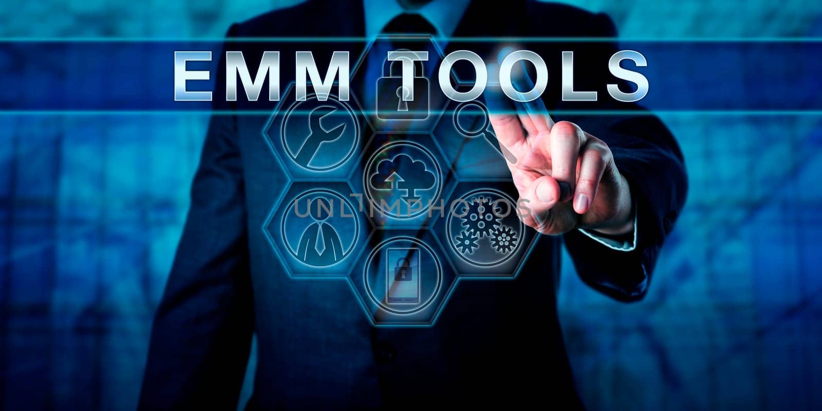 Corporate manager pressing EMM TOOLS on an interactive touch screen interface. Business metaphor and mobile technology concept for enterprise mobility management under a bring your own device policy.