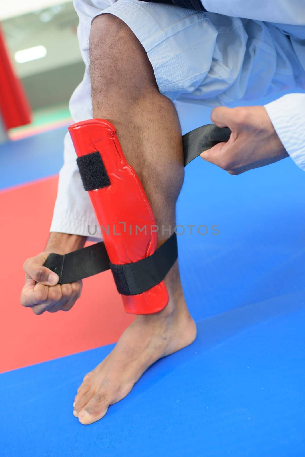 Martial artist attaching leg guard