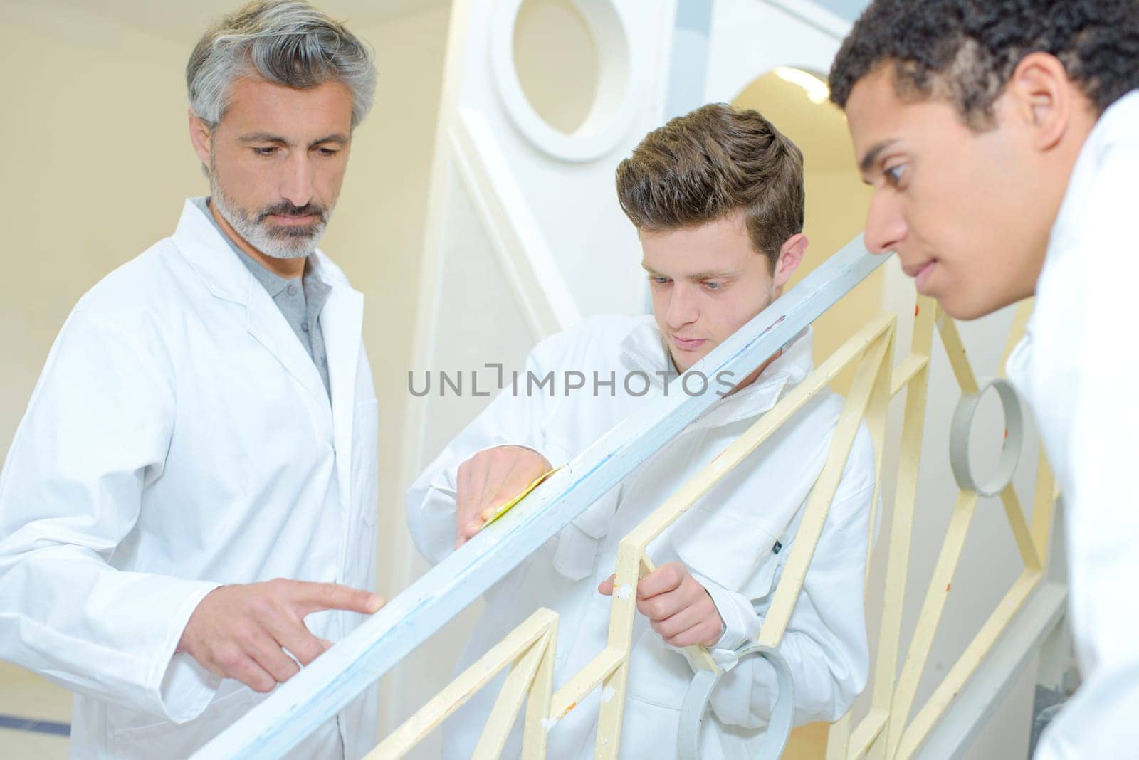Apprentices preparing surface to repaint