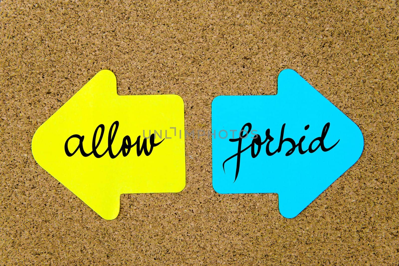 Message Allow versus Forbid on yellow and blue paper notes as opposite arrows pinned on cork board with thumbtacks. Choice conceptual image