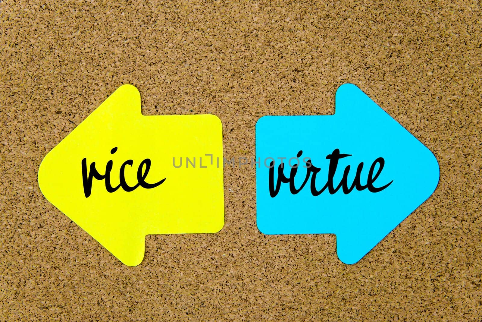 Message Vice versus Virtue on yellow and blue paper notes as opposite arrows pinned on cork board with thumbtacks. Choice conceptual image