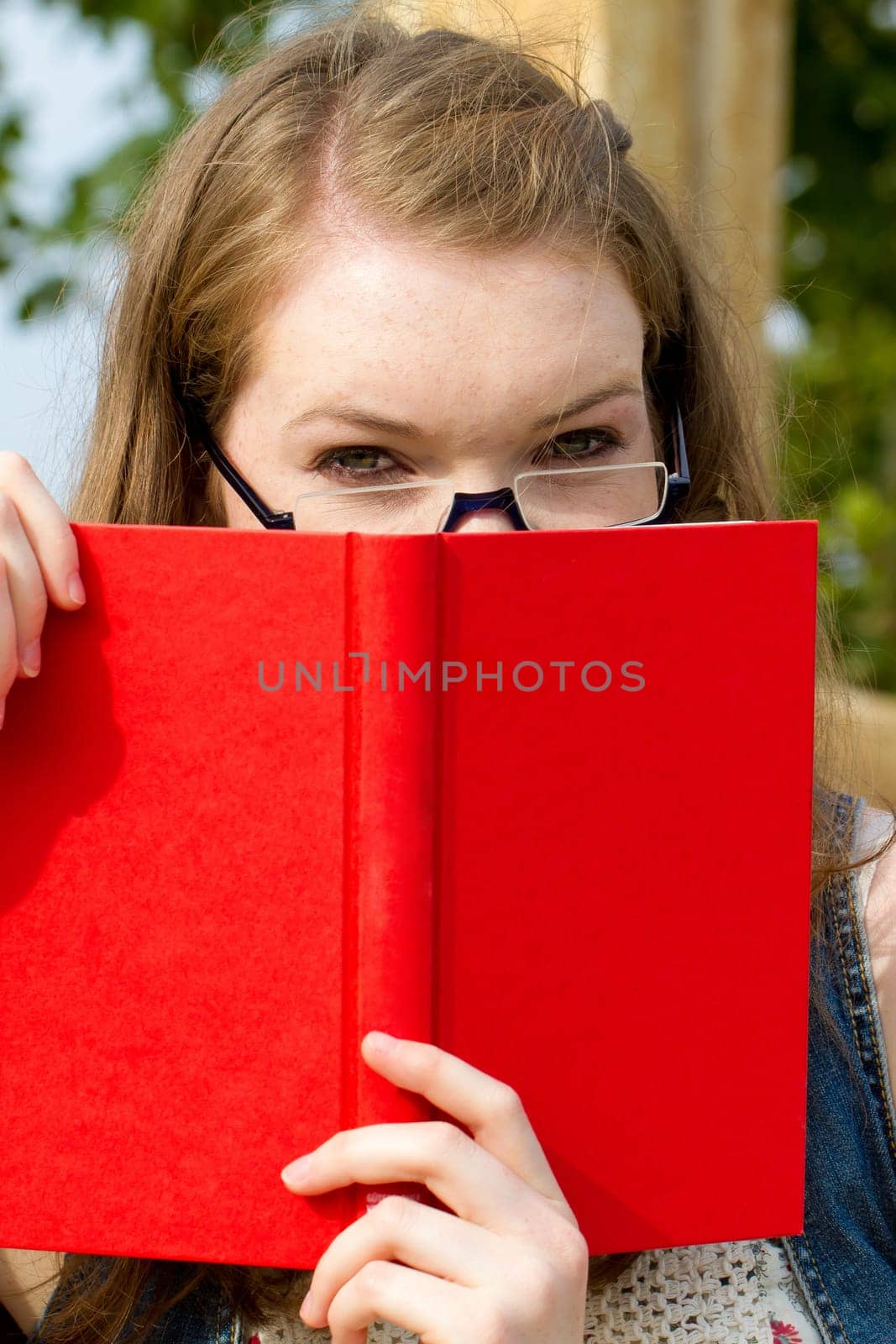 Young woman with book in nature
