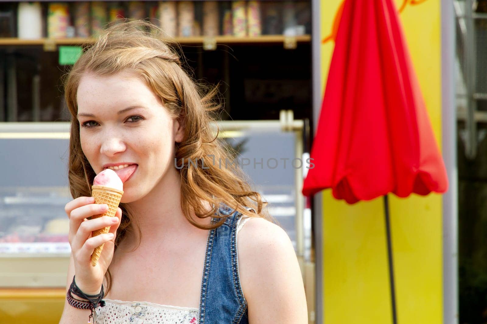 Young woman with ice cream bag in front of an ice cream parlour