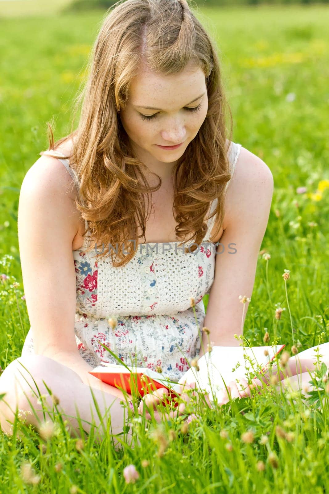 Girl with book on a meadow