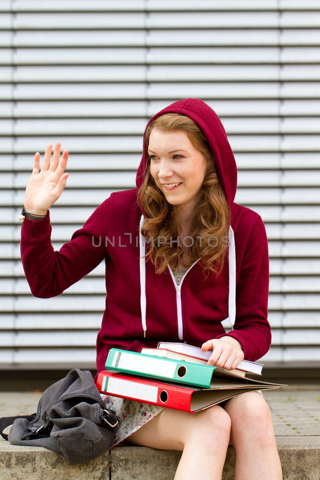Schoolgirl in the pausenhof waves to her friend