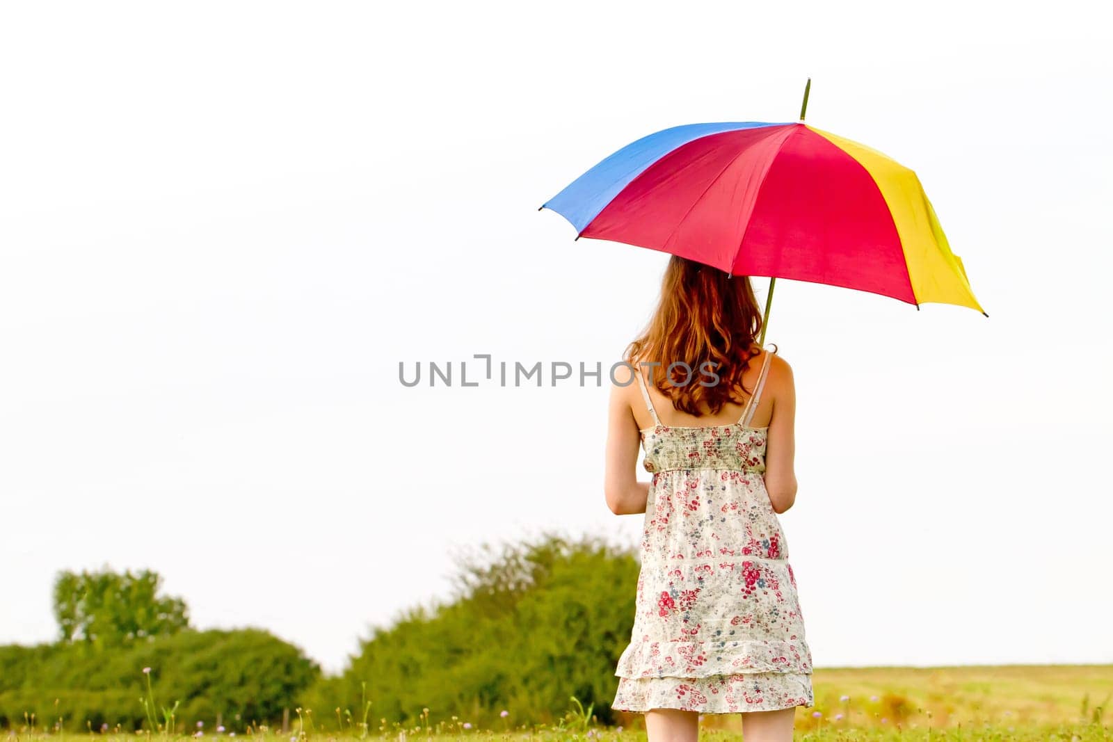 Young woman in summer with colorful umbrella