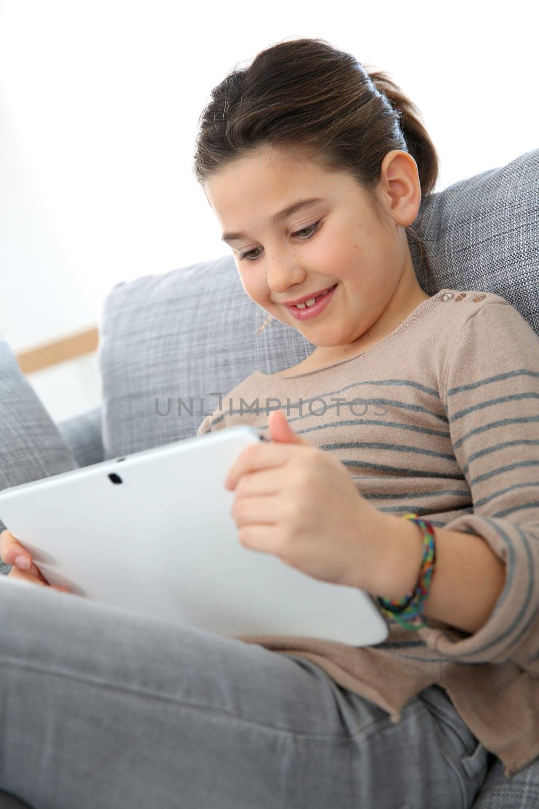 Young 8-year-old girl playing with tablet
