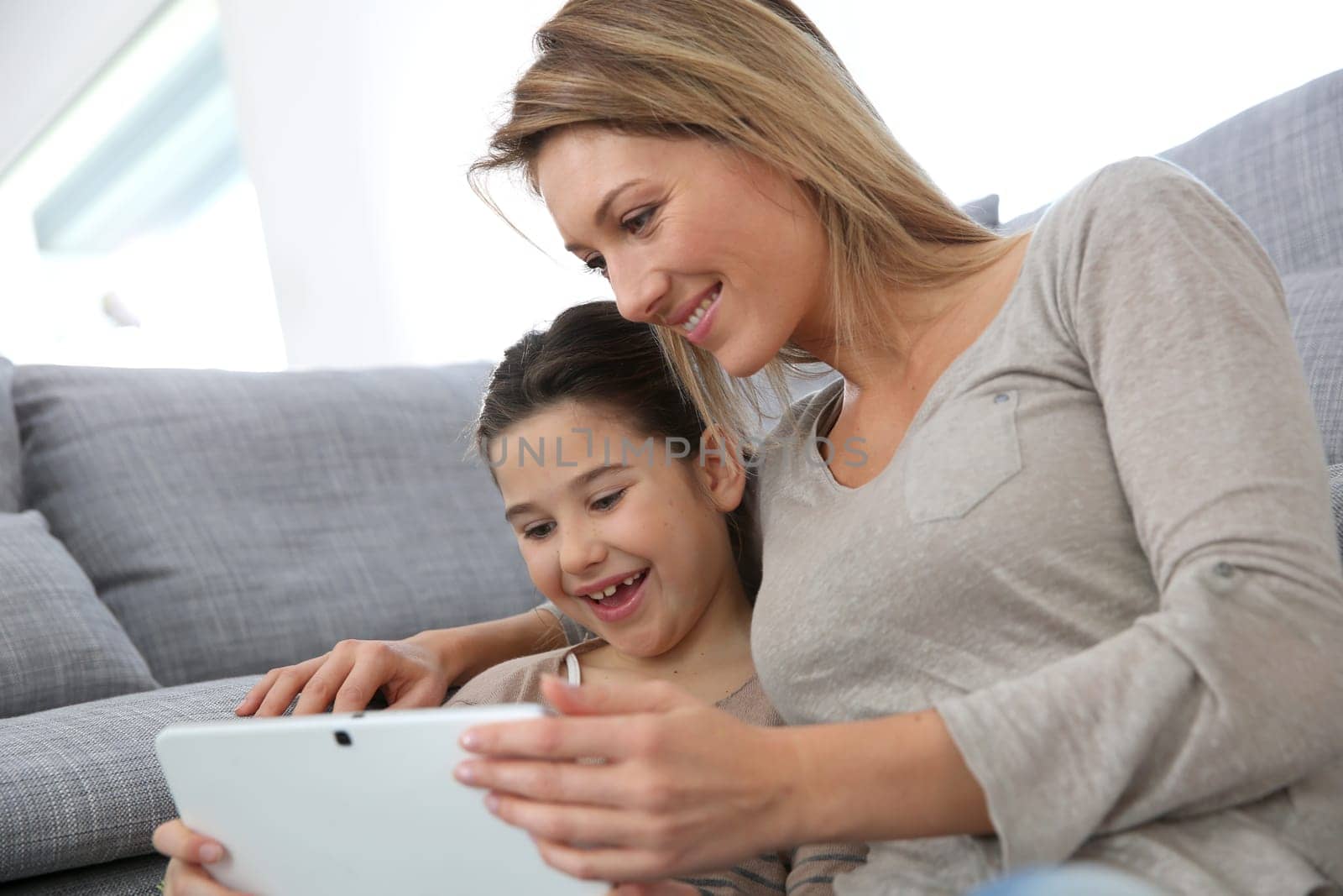 Mother and daughter playing with digital tablet