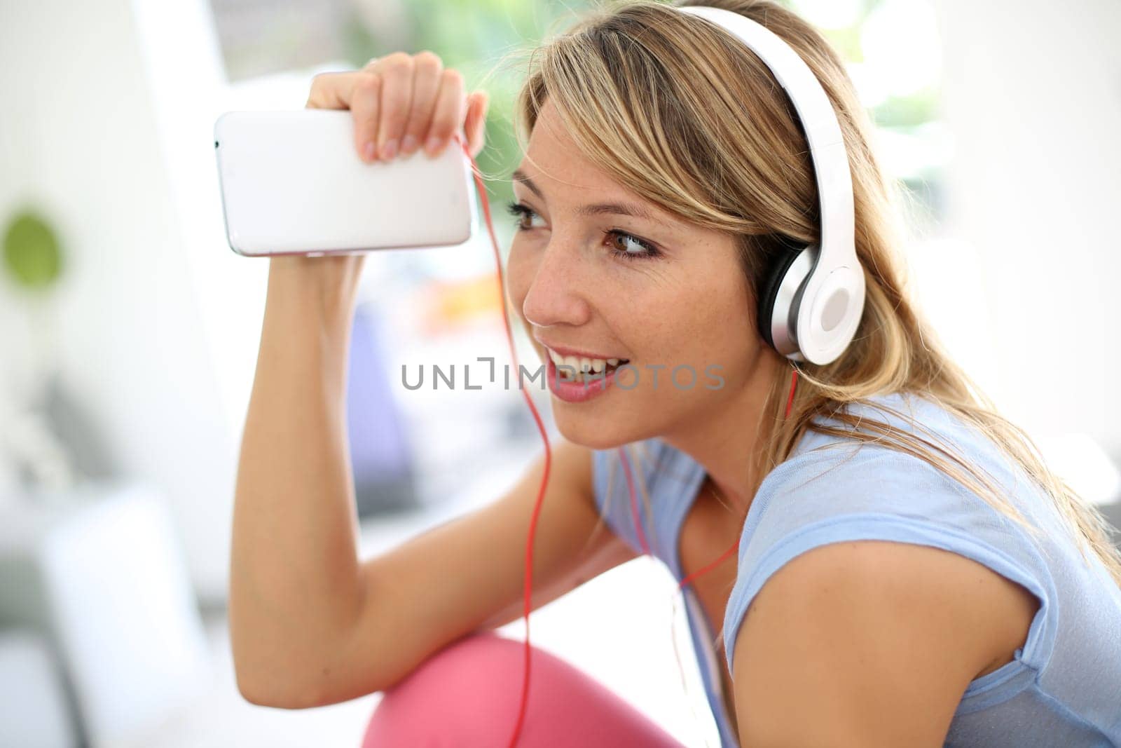 Blond woman listening to music with headphones