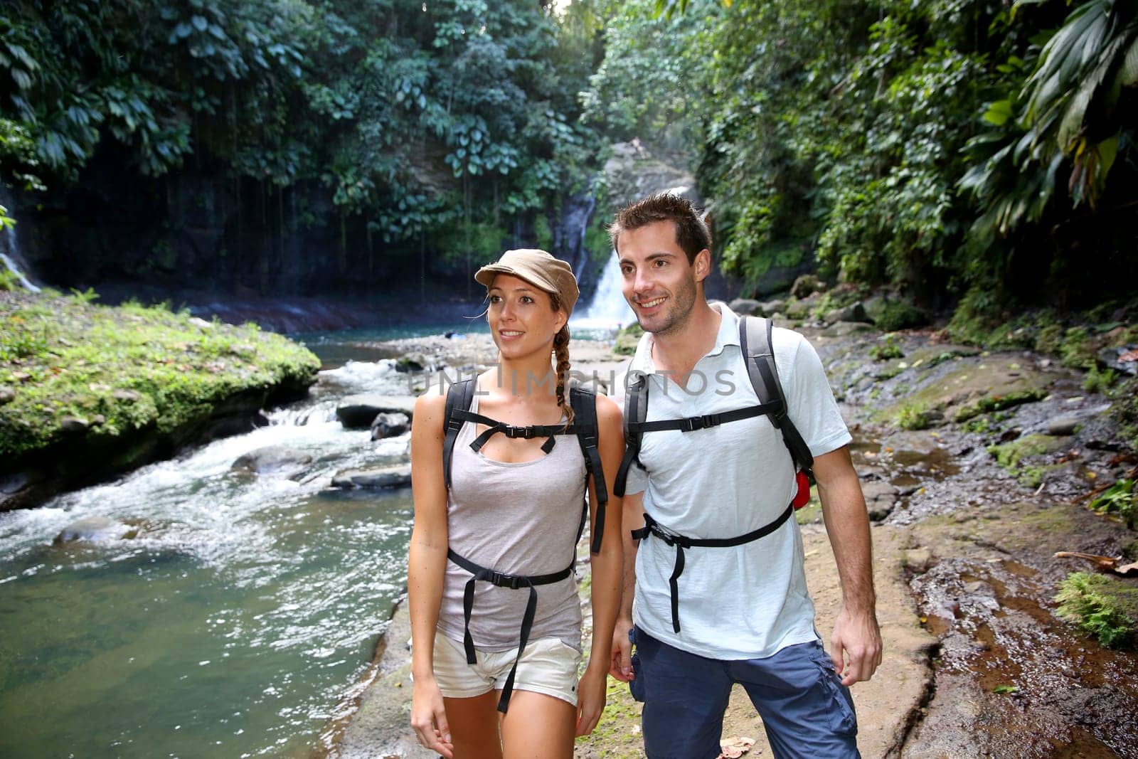 Trekkers reaching waterfall in natural landscape