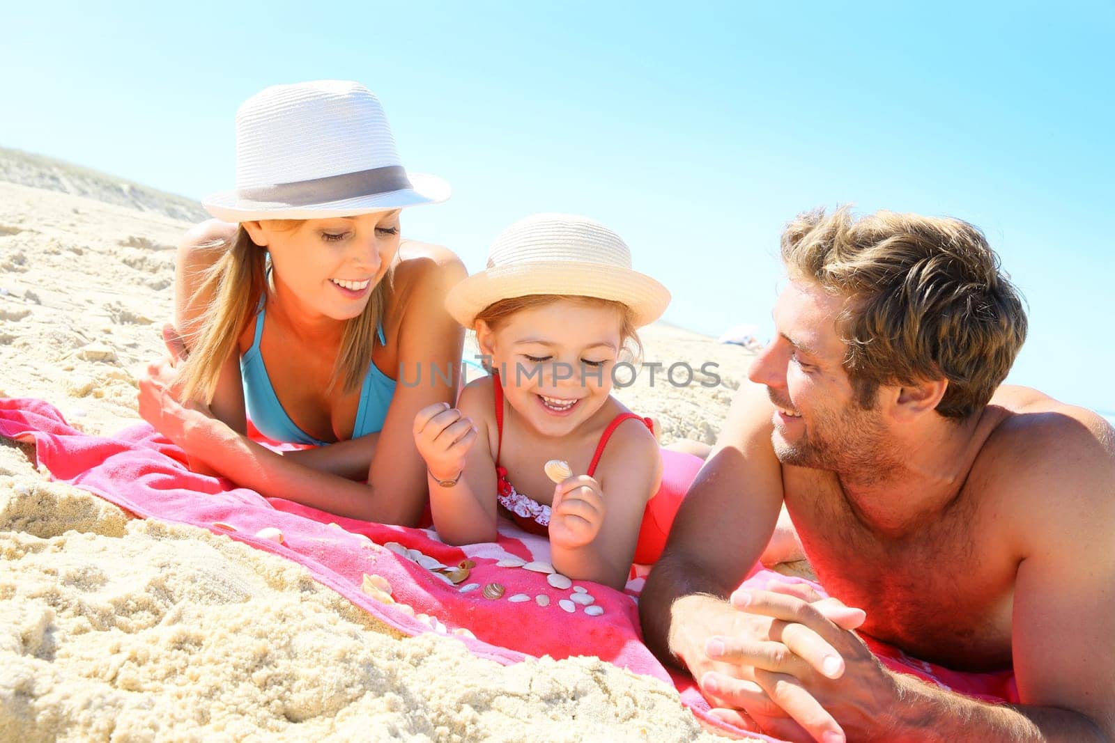 Family playing with seashells on the beach