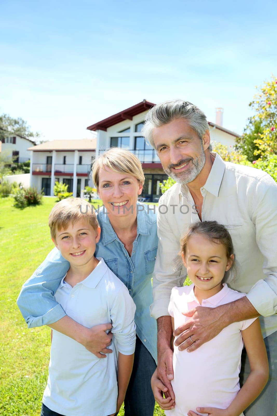 Happy family standing in home private garden